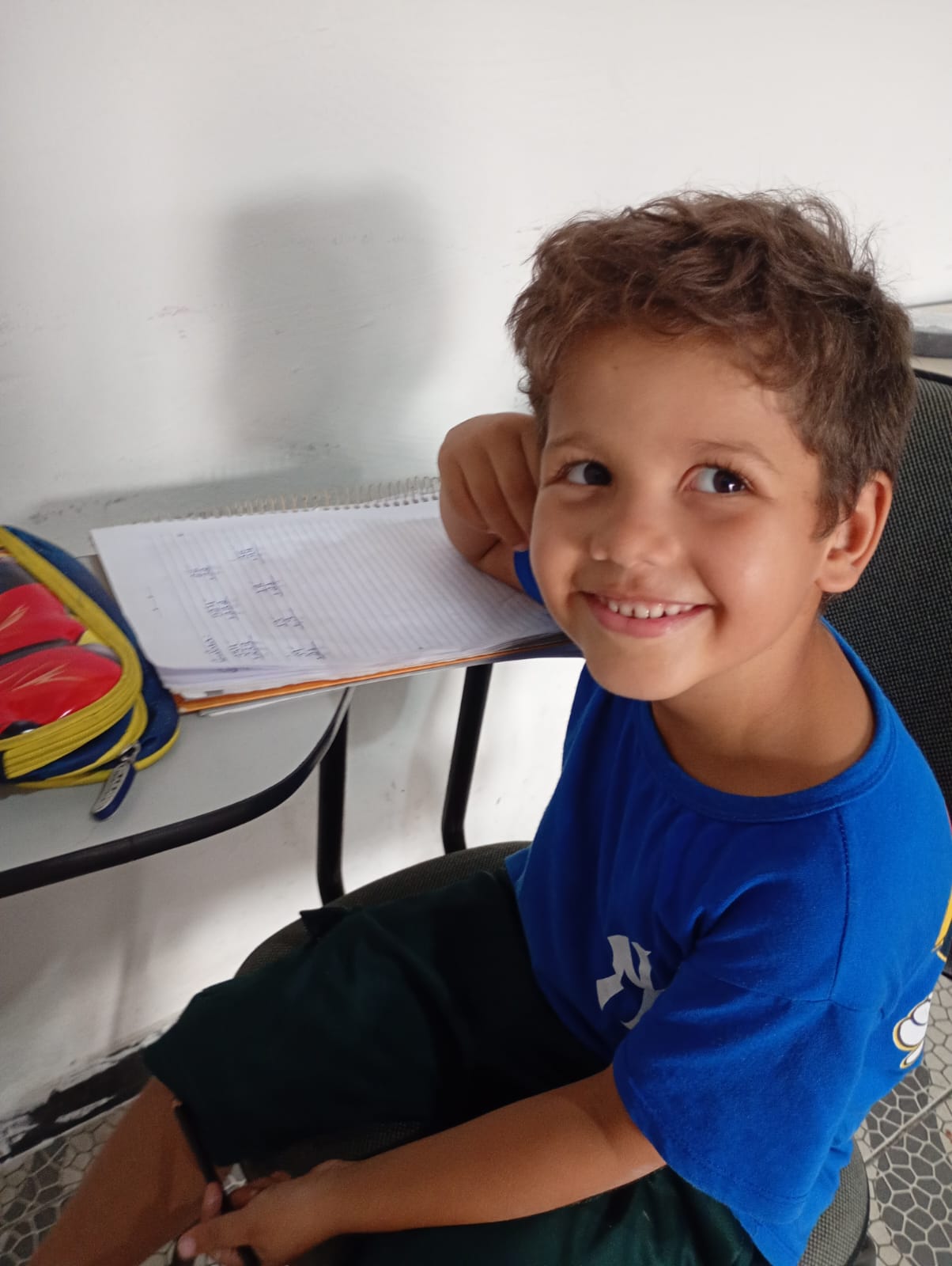 Aluno do projeto sorrindo durante a aula de reforço