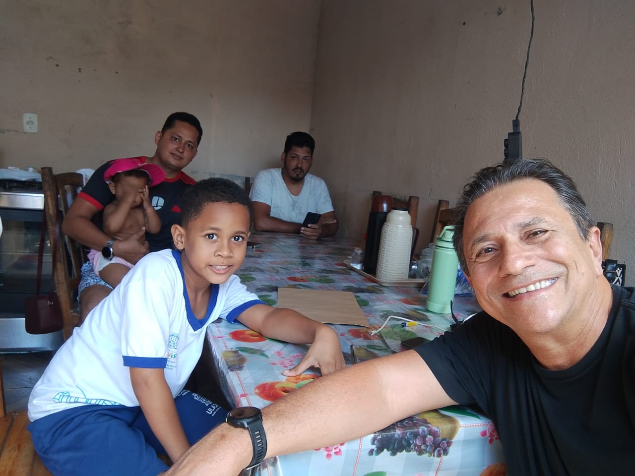 Visita do projeto à casa de um aluno, com a família reunida à mesa