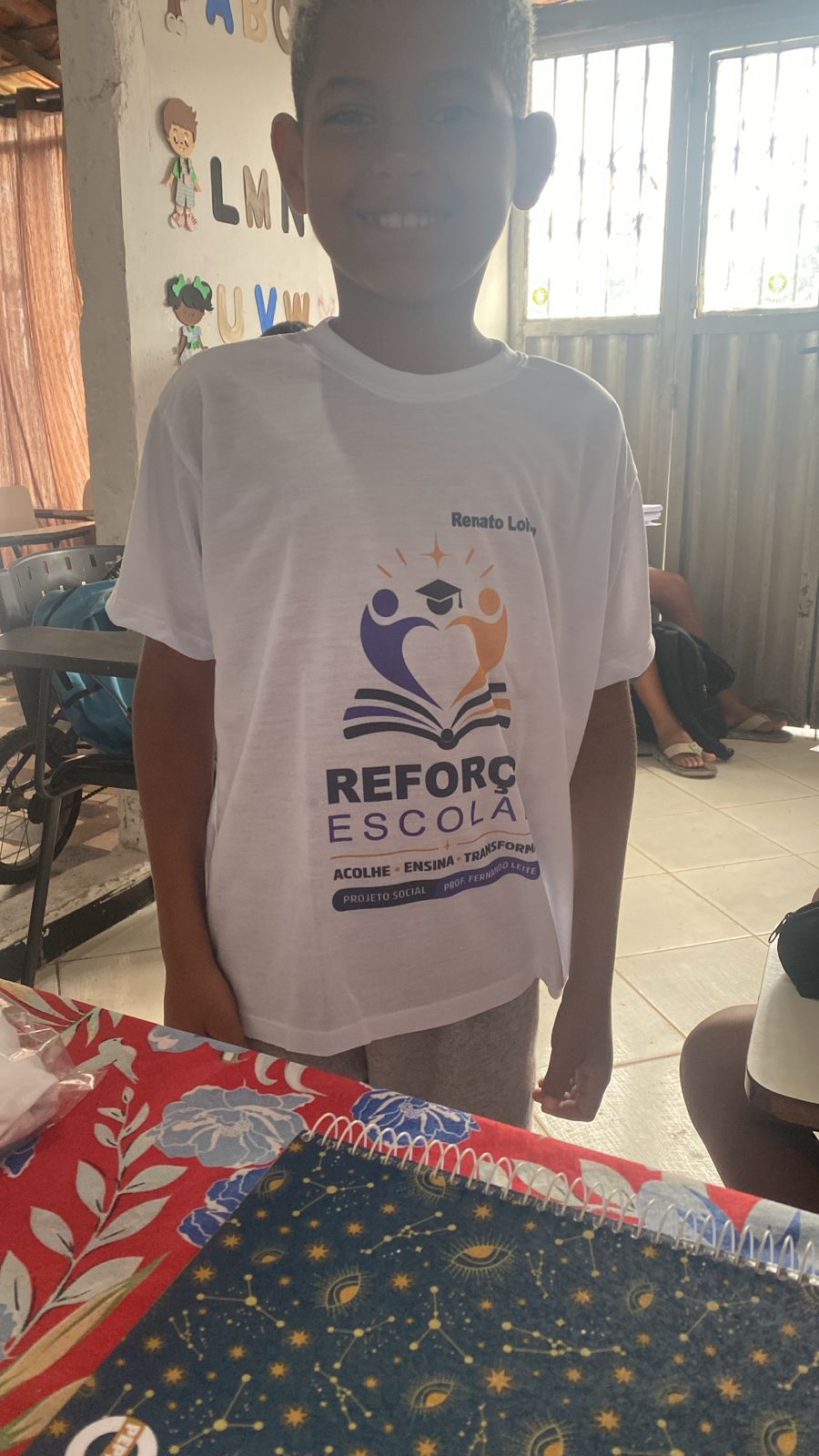 Aluno com a camiseta do reforço escolar na sala de aula