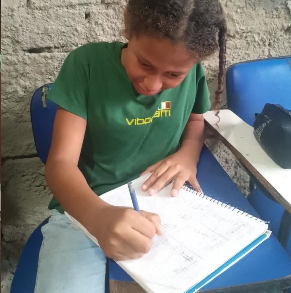 Aluna do projeto resolvendo exercícios no caderno