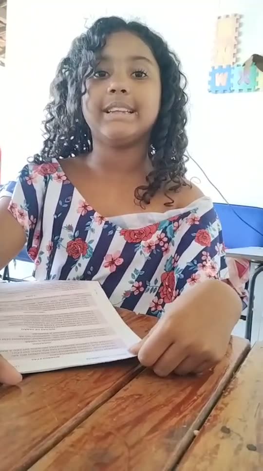 Aluna do projeto lendo em voz alta durante o reforço