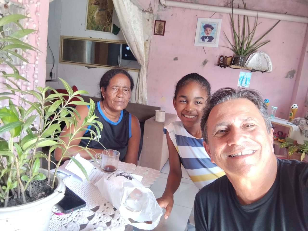 Visita do projeto à casa de uma aluna, ao lado da avó, na sala da família