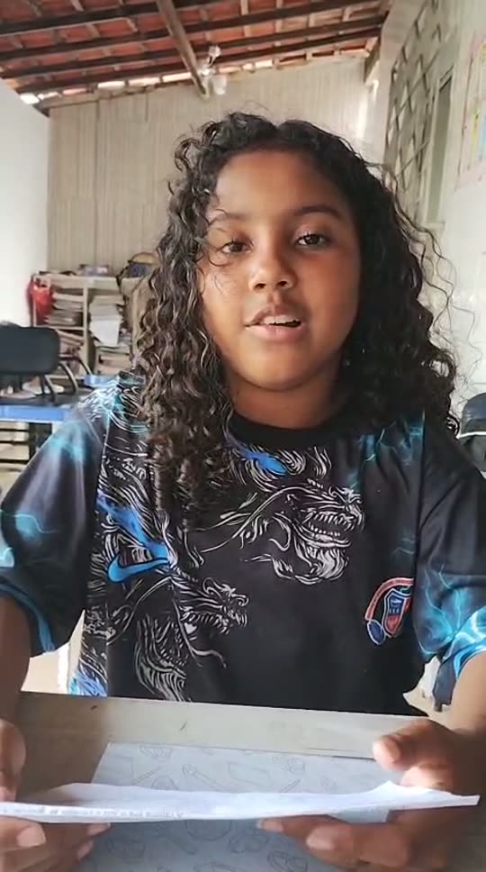 Aluna do projeto lendo o caderno durante o reforço