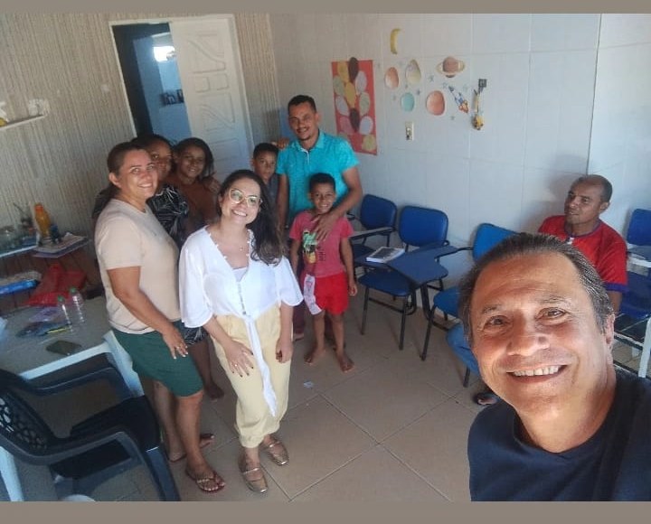 Prof. Fernando com famílias e crianças reunidos na sala do reforço