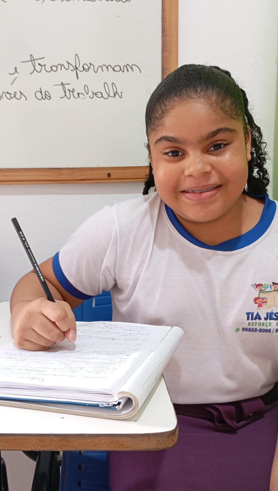 Aluna do projeto fazendo exercícios no caderno