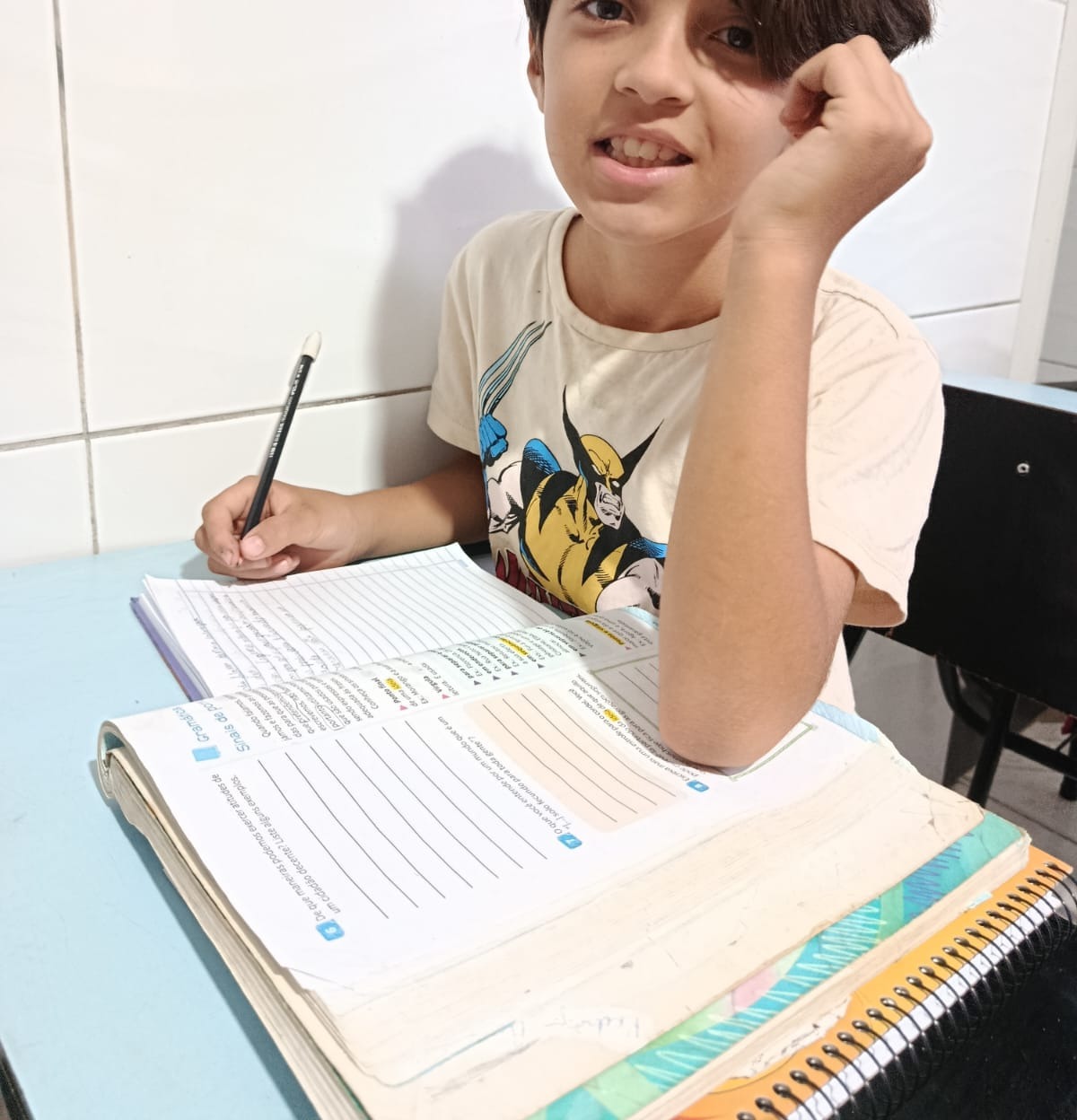 Aluno do projeto estudando com caderno aberto na mesa