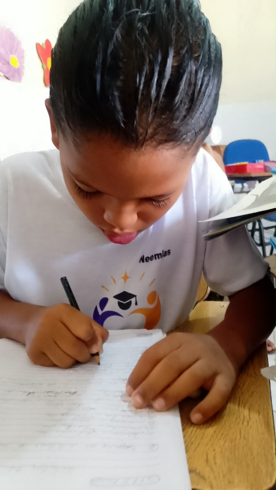 Aluno do projeto concentrado escrevendo no caderno durante a aula