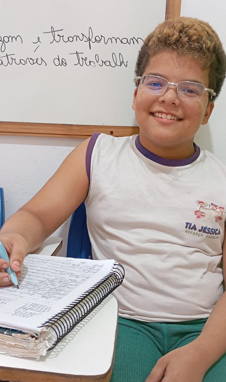 Aluno do projeto de óculos anotando a lição no caderno