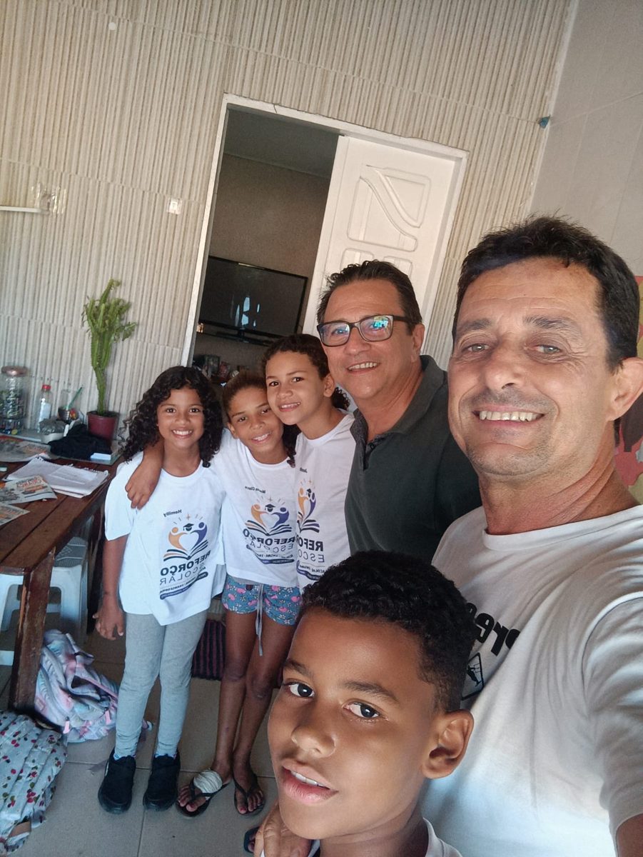 Crianças do projeto com as camisetas do reforço, ao lado dos coordenadores