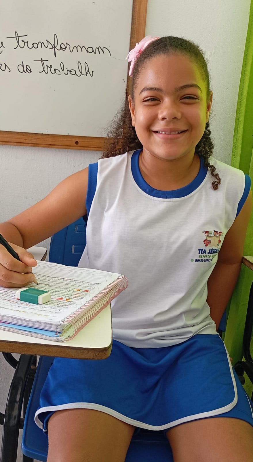 Aluna do projeto escrevendo no caderno espiral