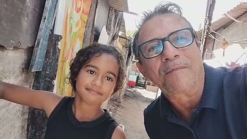 Professor Fernando ao lado da Ágda, aluna de 9 anos, na comunidade